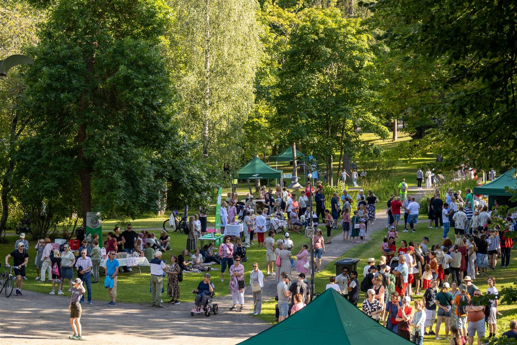 Pusupuistossa on paljon ihmisiä viettämässä kesäpäivää Mariannen nimppareiden merkeissä.