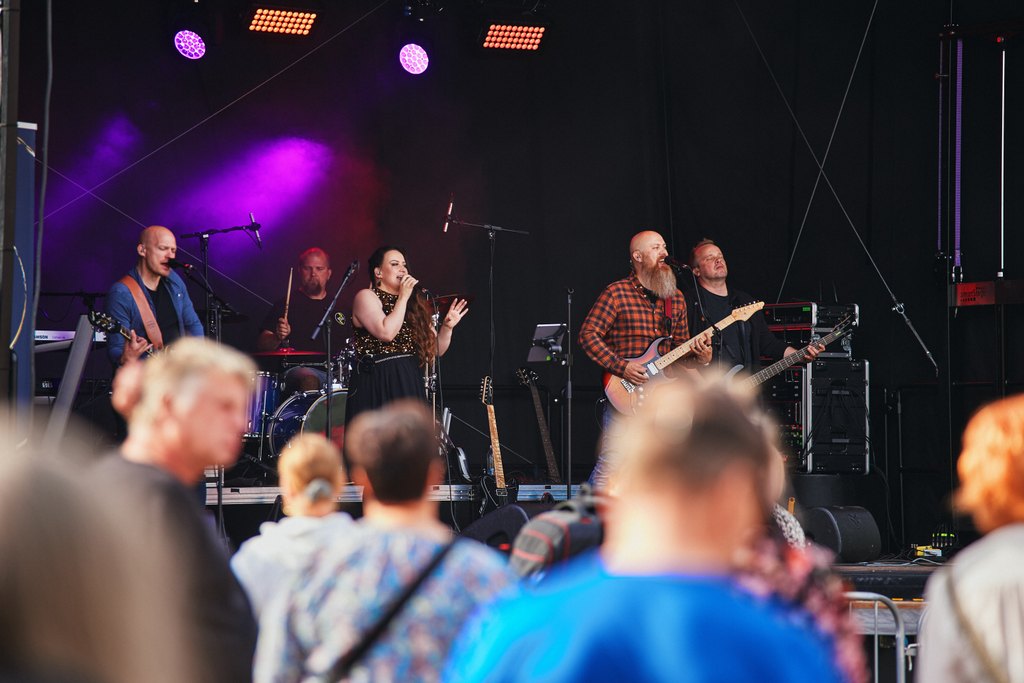 Ihmiset katsovat lavalla esiintyvää bändiä.